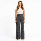 Woman modelling grey wide-leg trousers on a white background